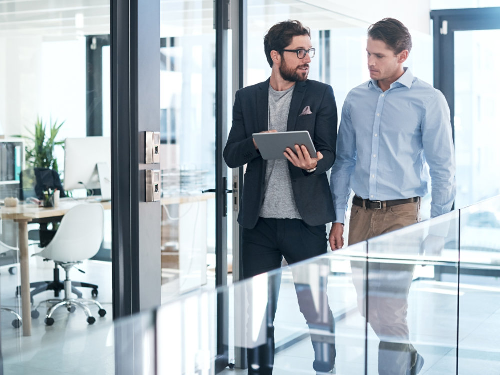 Shot of two businessmen using a digital tablet together in an office