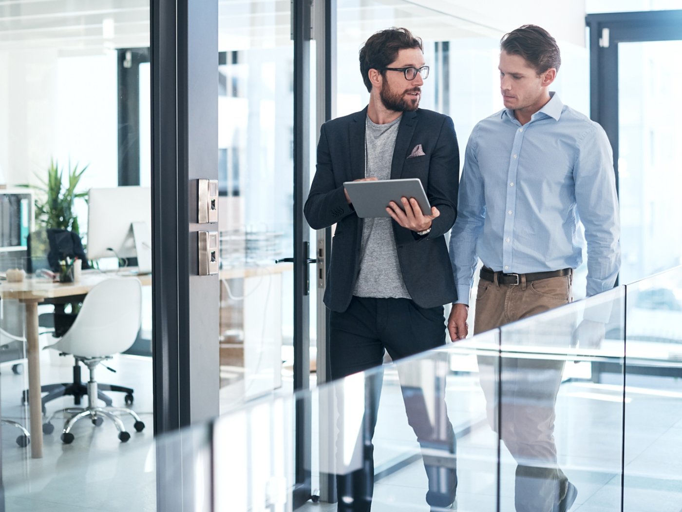 Shot of two businessmen using a digital tablet together in an office