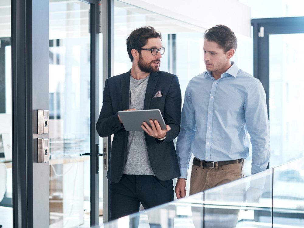 Shot of two businessmen using a digital tablet together in an office