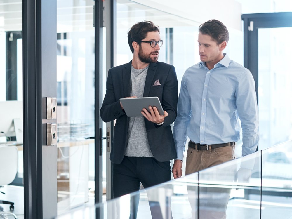 Shot of two businessmen using a digital tablet together in an office