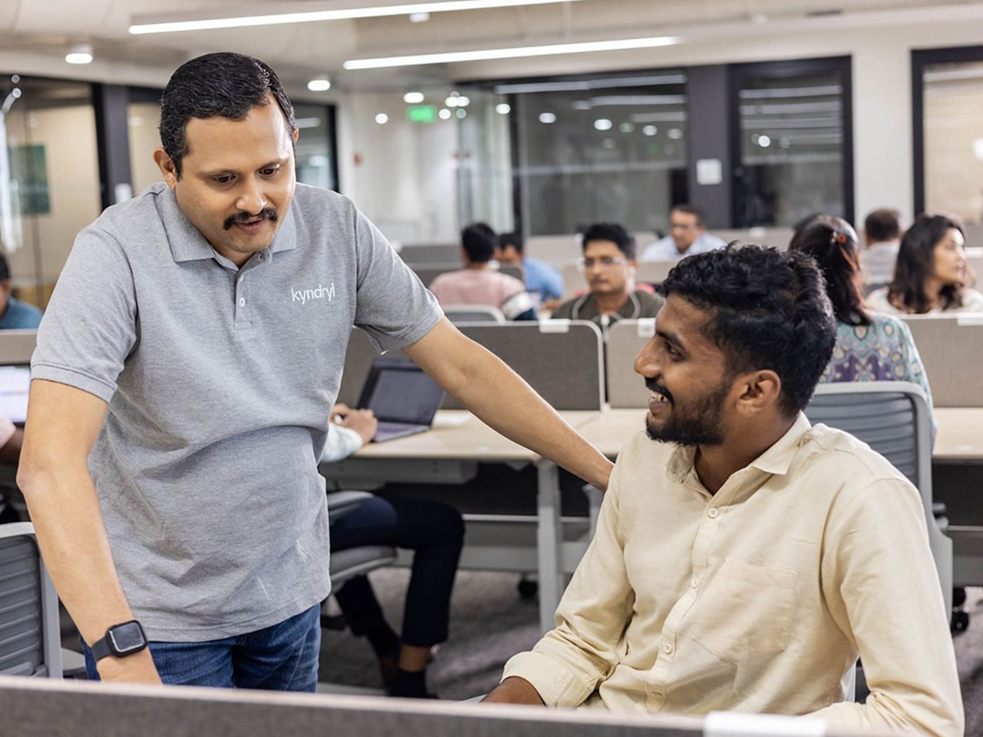two Kyndryl employees from India discussing a work project.
