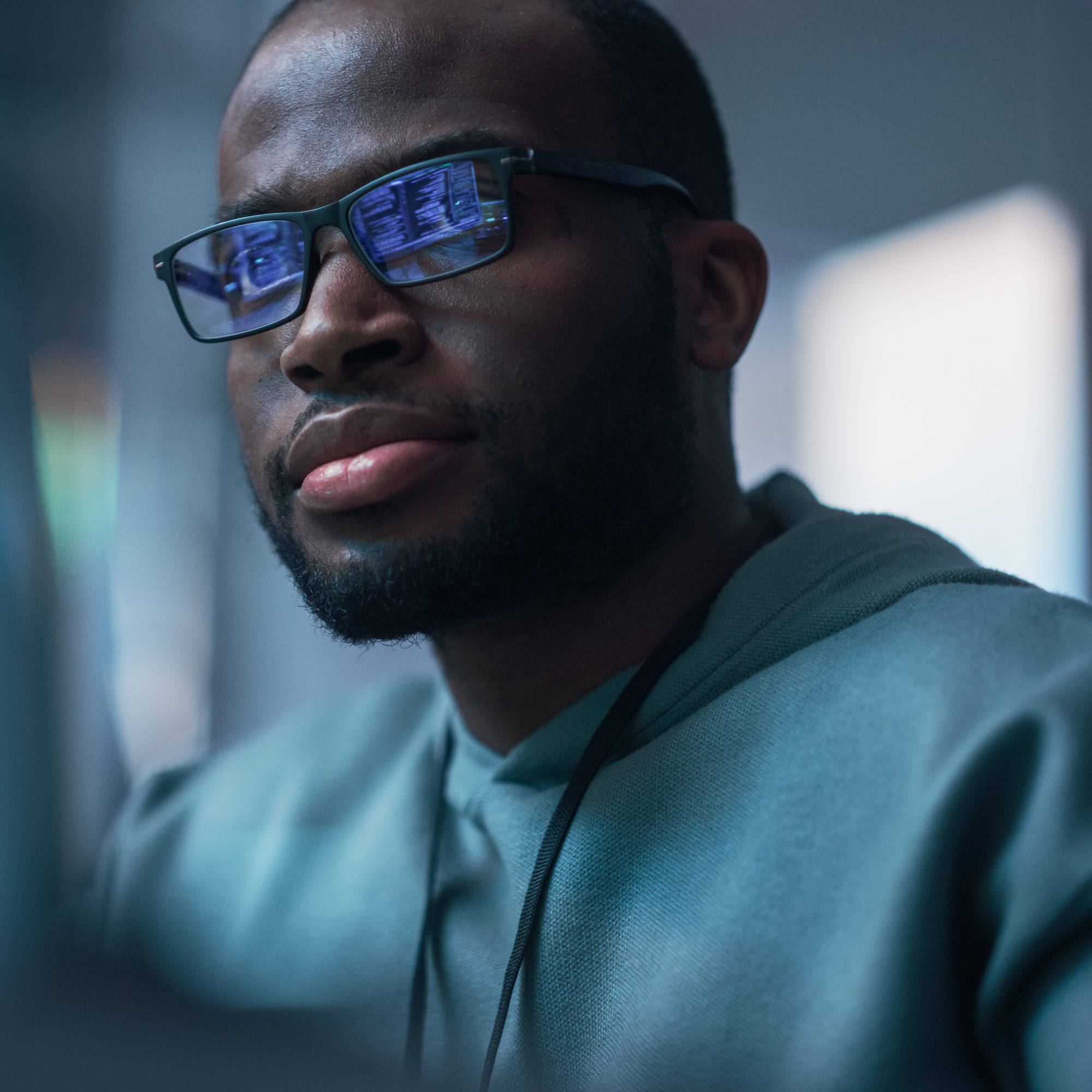Close Up Portrait of Black Man Working on Computer, Lines of Code Language Reflecting on his Glasses. Male Programmer Developing New Software, Managing Cybersecurity Defence Project.
