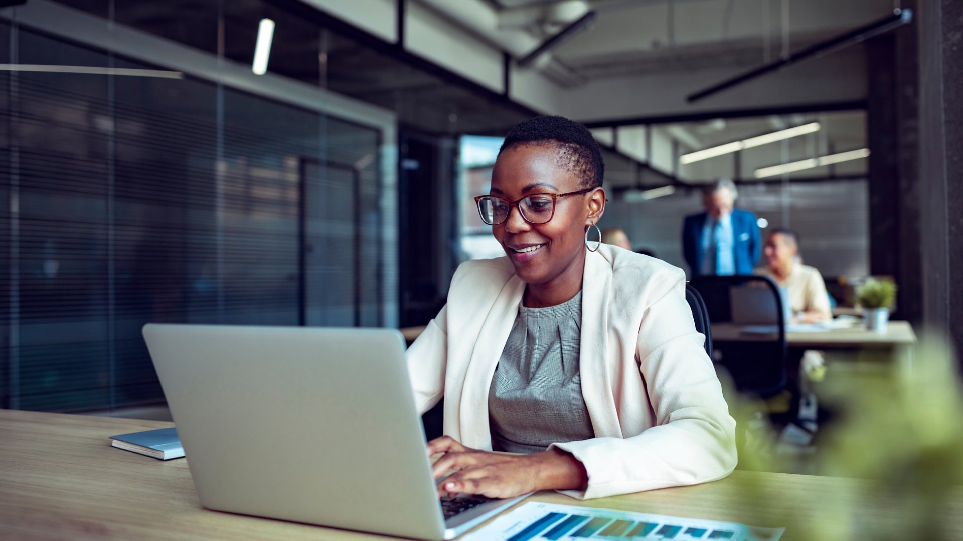 Smiling businesswoman working on laptop in office