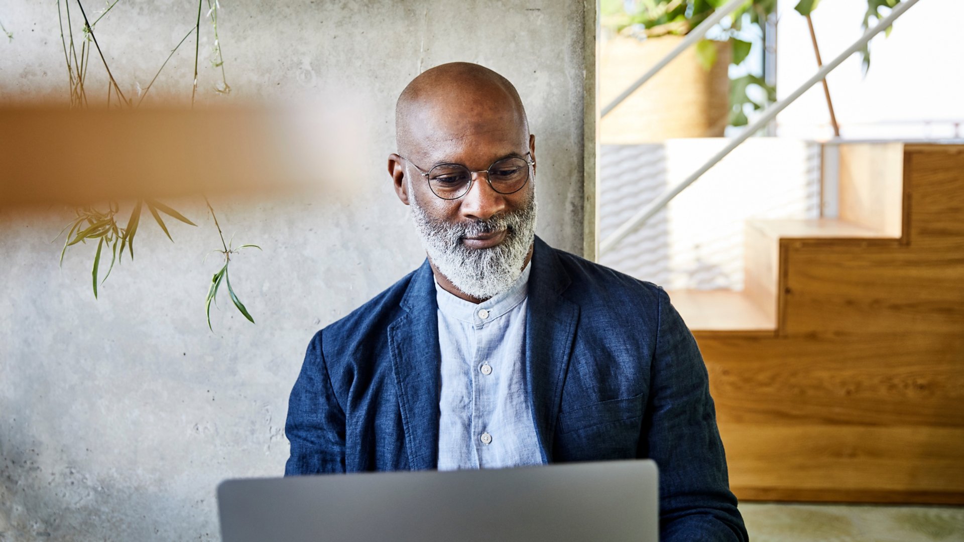Smiling man working on laptop at home