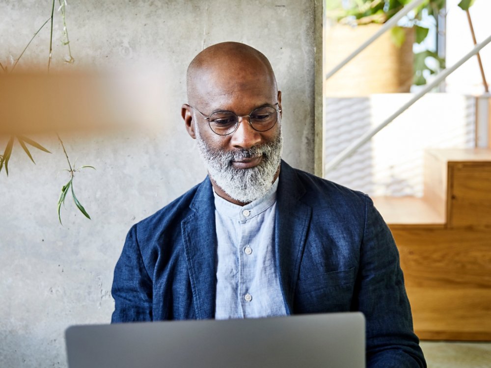 Smiling man working on laptop at home