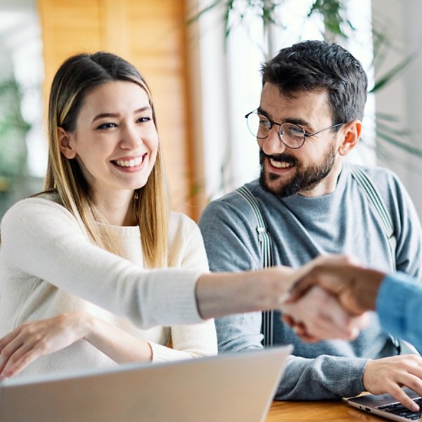 Real estate agent with couple shaking hands closing a deal