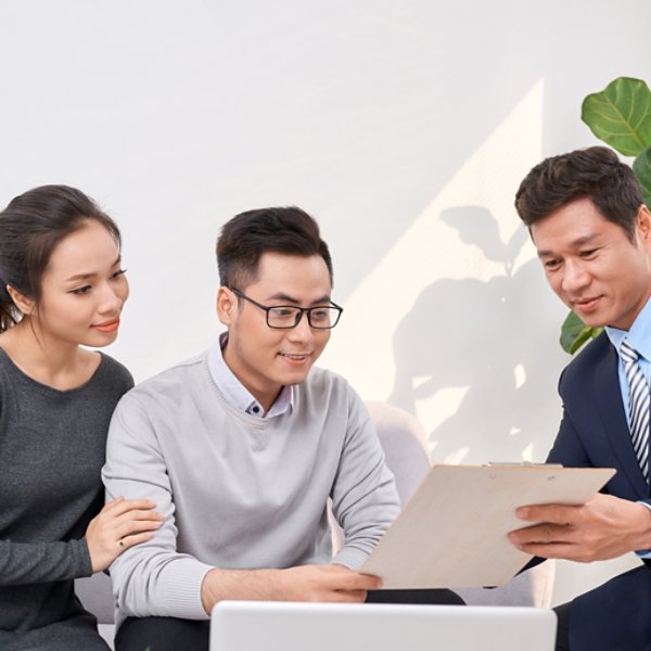 Sales Consultant showing new investment plans to young asian couple