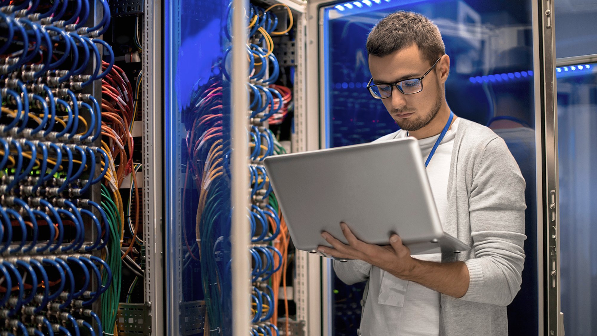 IT technician with laptop on in server room