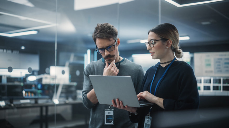 Multicultural Chief Technology Officer Talking to Software Developer, Discussing Neural Network Updates in High Tech Research and Development Facility. Professional Computer Specialists at Work