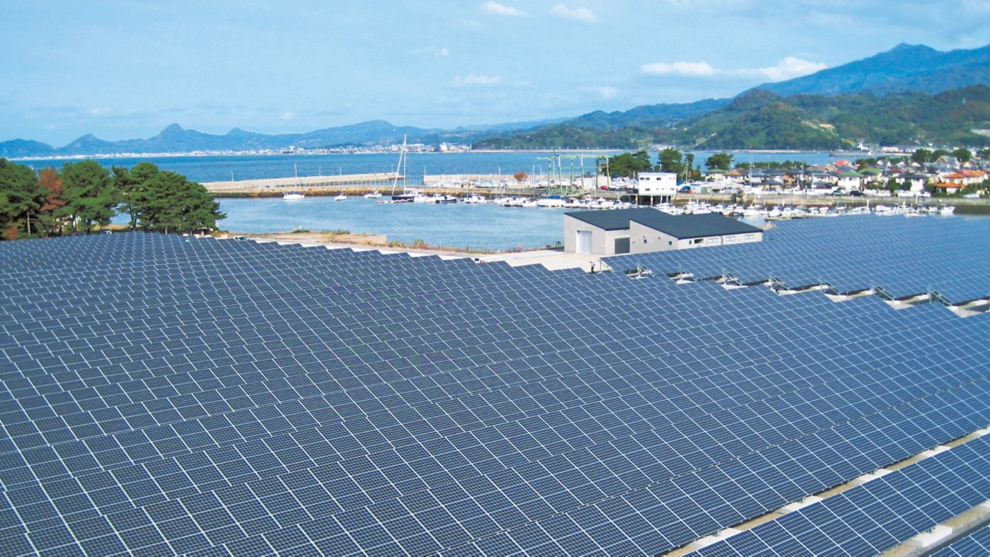japanese solar field overlooking water and mountains