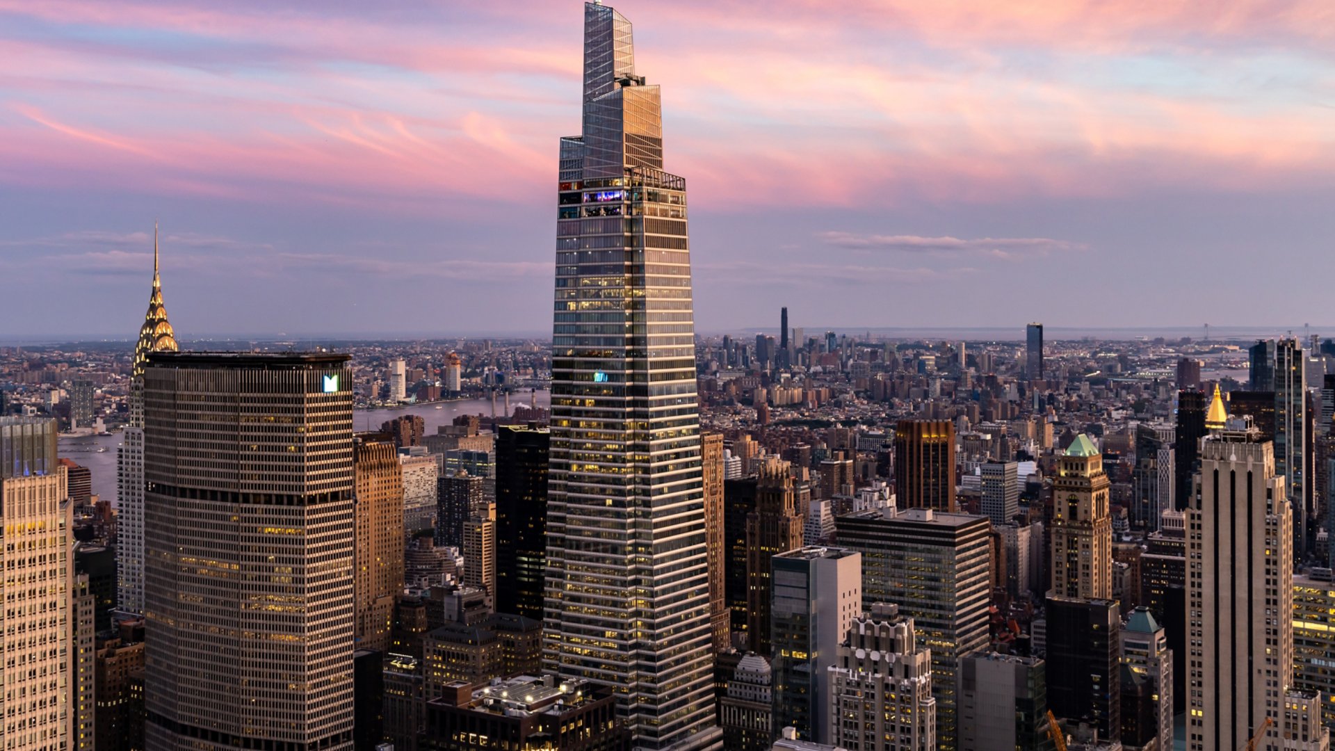 Aerial View of One Vanderbilt Met Life Building NYC Skyline with pink skies and clouds.