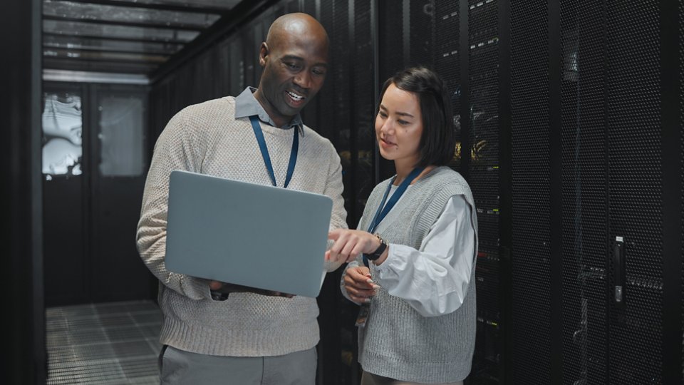Business, black man and woman with laptop, servers and cyber security for connection, data analytics and conversation. IT specialist, female programmer and employees with device and cloud computing.