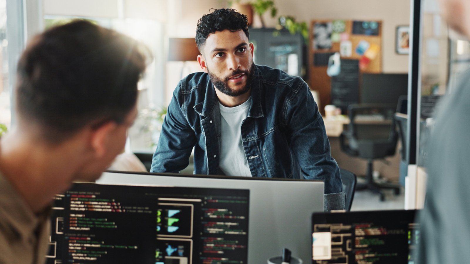 Men, discussion and meeting with computer for coding solutions, problem solving or ideas at office. Male people, designers or developers working on technology for software development at workplace.