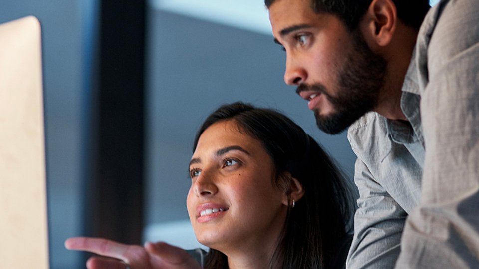 man and woman discussing work in front of computer - 4x3 version