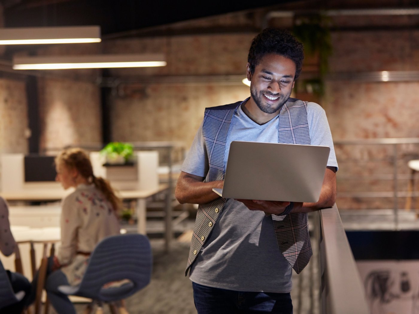 man smiling while working on a laptop 4X3