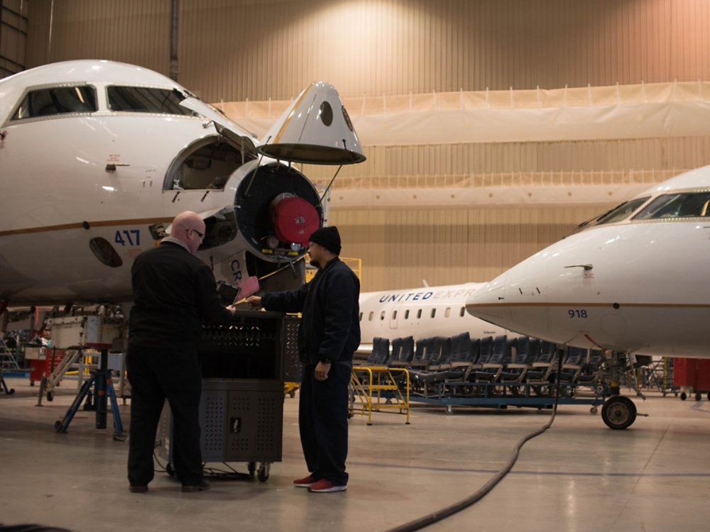mechanics talking in front of plane