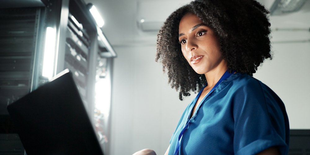Computer, server room and woman programming software, update or system network maintenance. Technology, data center or technician on laptop for information, cyber security or code for cloud computing.