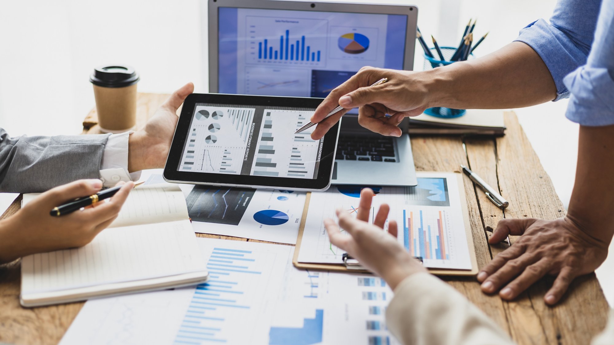Business people discuss marketing growth chart and make business plan. Business meeting, financial consultants brainstorm analysis of statistical charts in financial reporting documents.