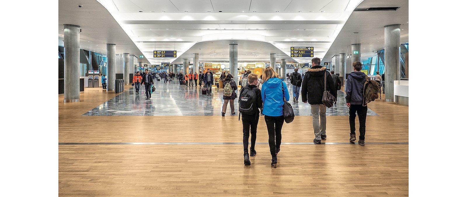 Travelers walking through modern airport terminal