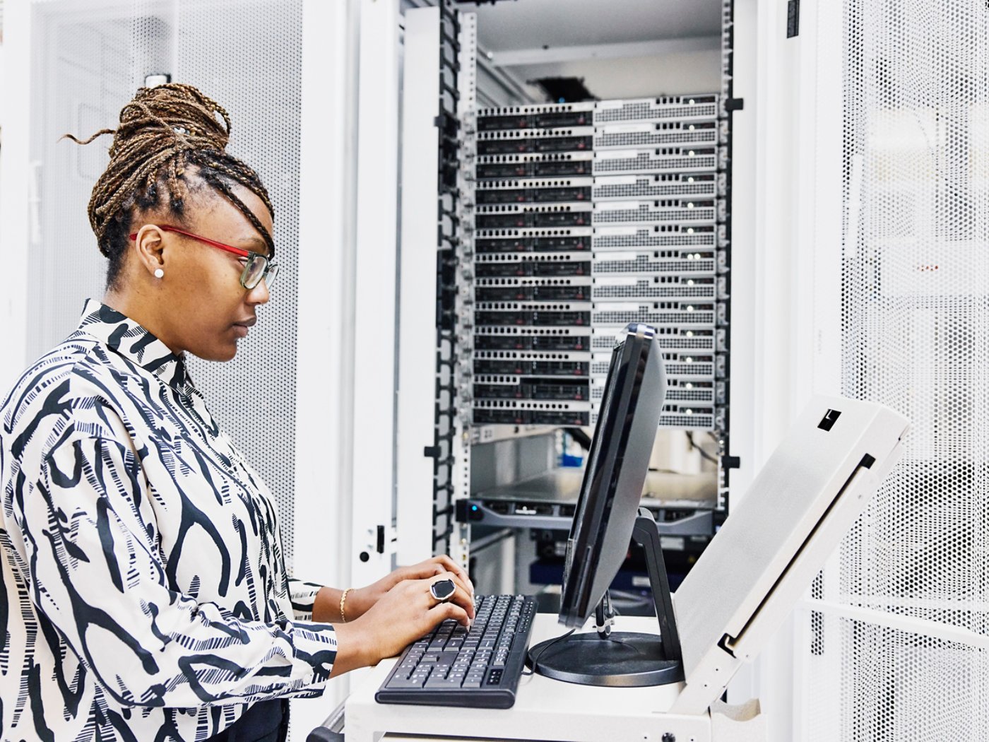 Medium shot of female IT professional configuring server in data center