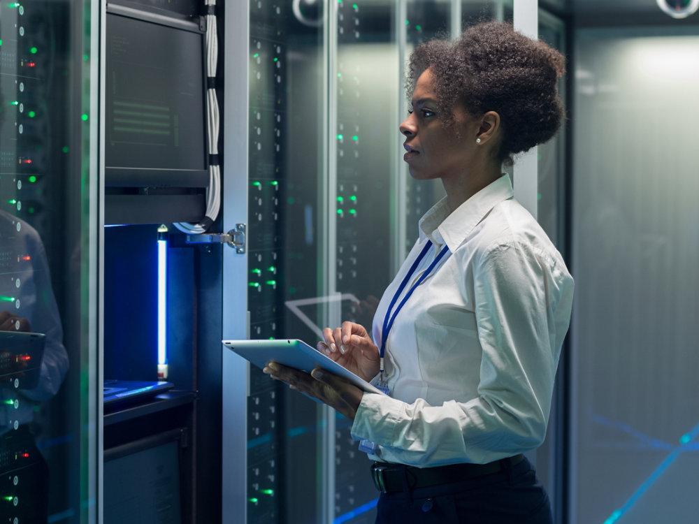 Medium shot of female technician working on a tablet in a data center 