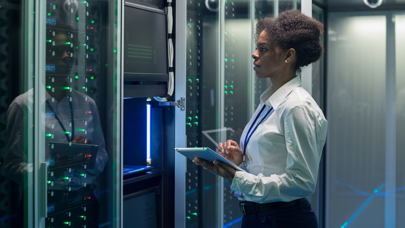 Medium shot of female technician working on a tablet in a data center 