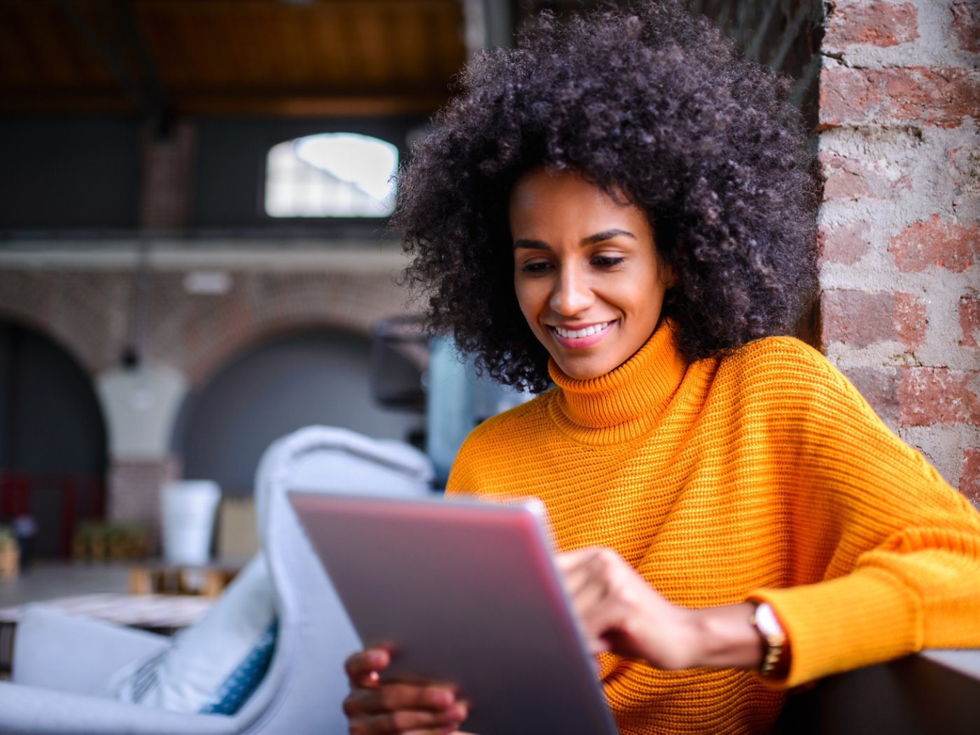 Smiling African American woman using digital tablet.