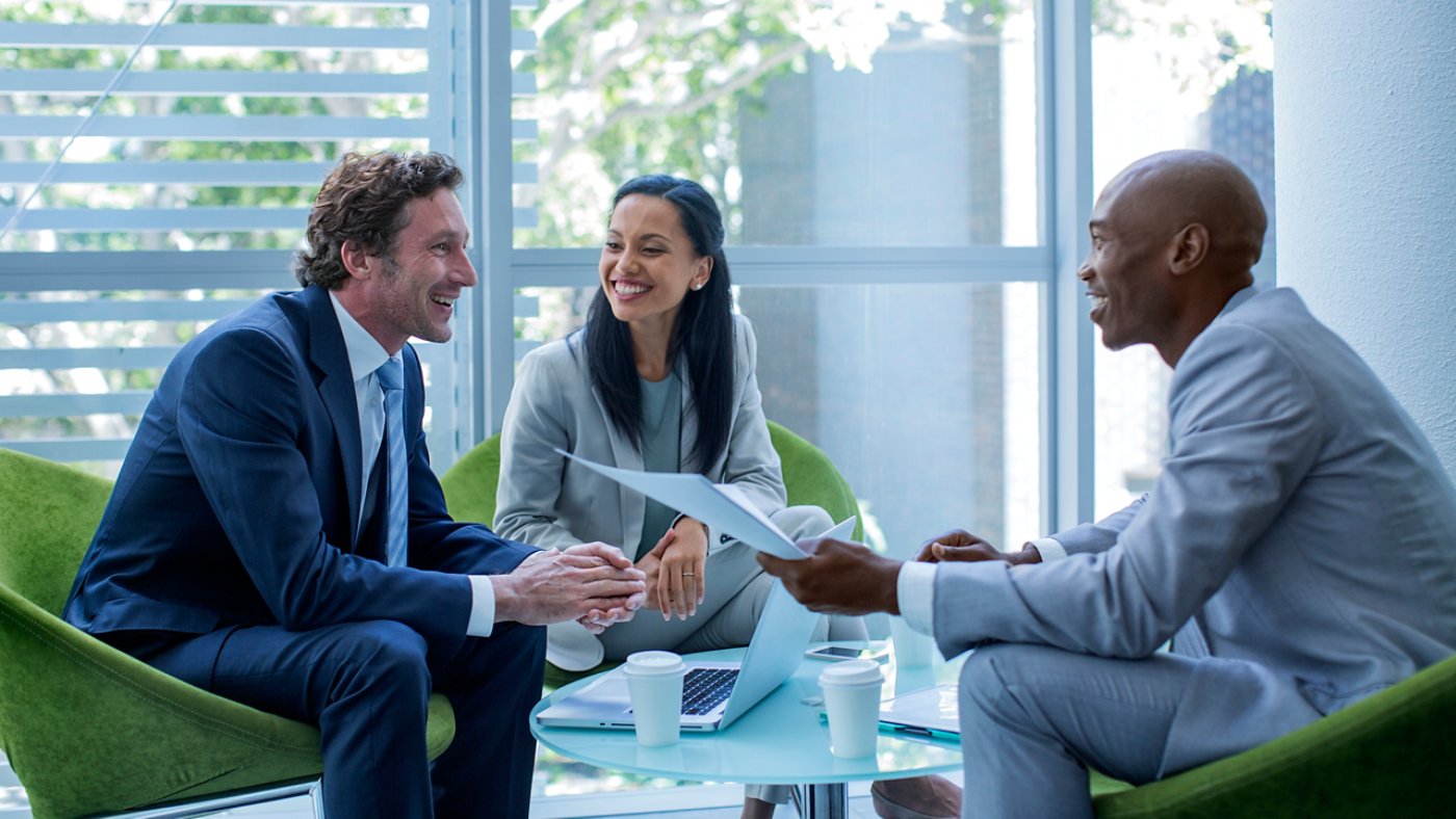 Happy multi-ethnic businesspeople discussing in office