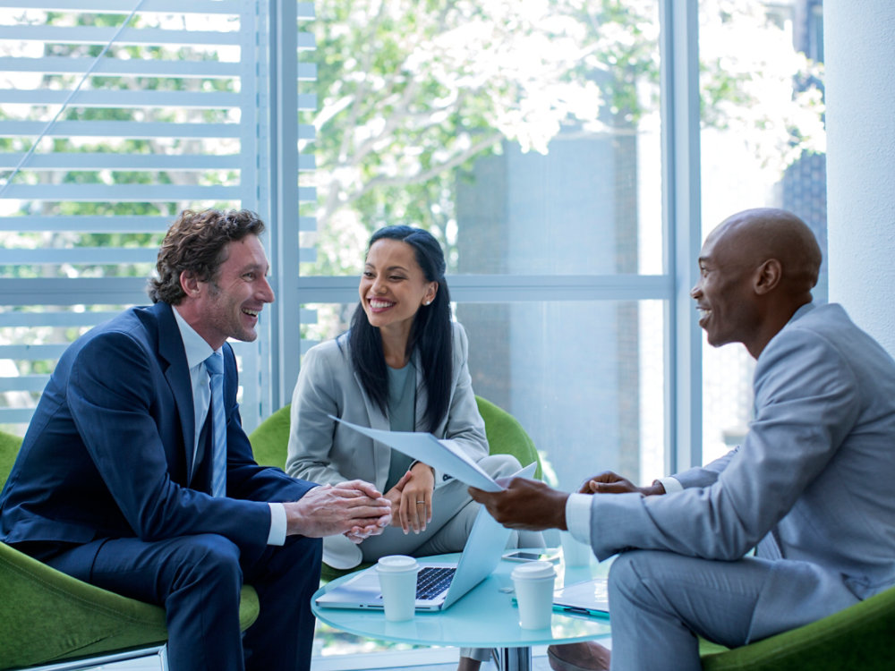 Happy multi-ethnic businesspeople discussing in office