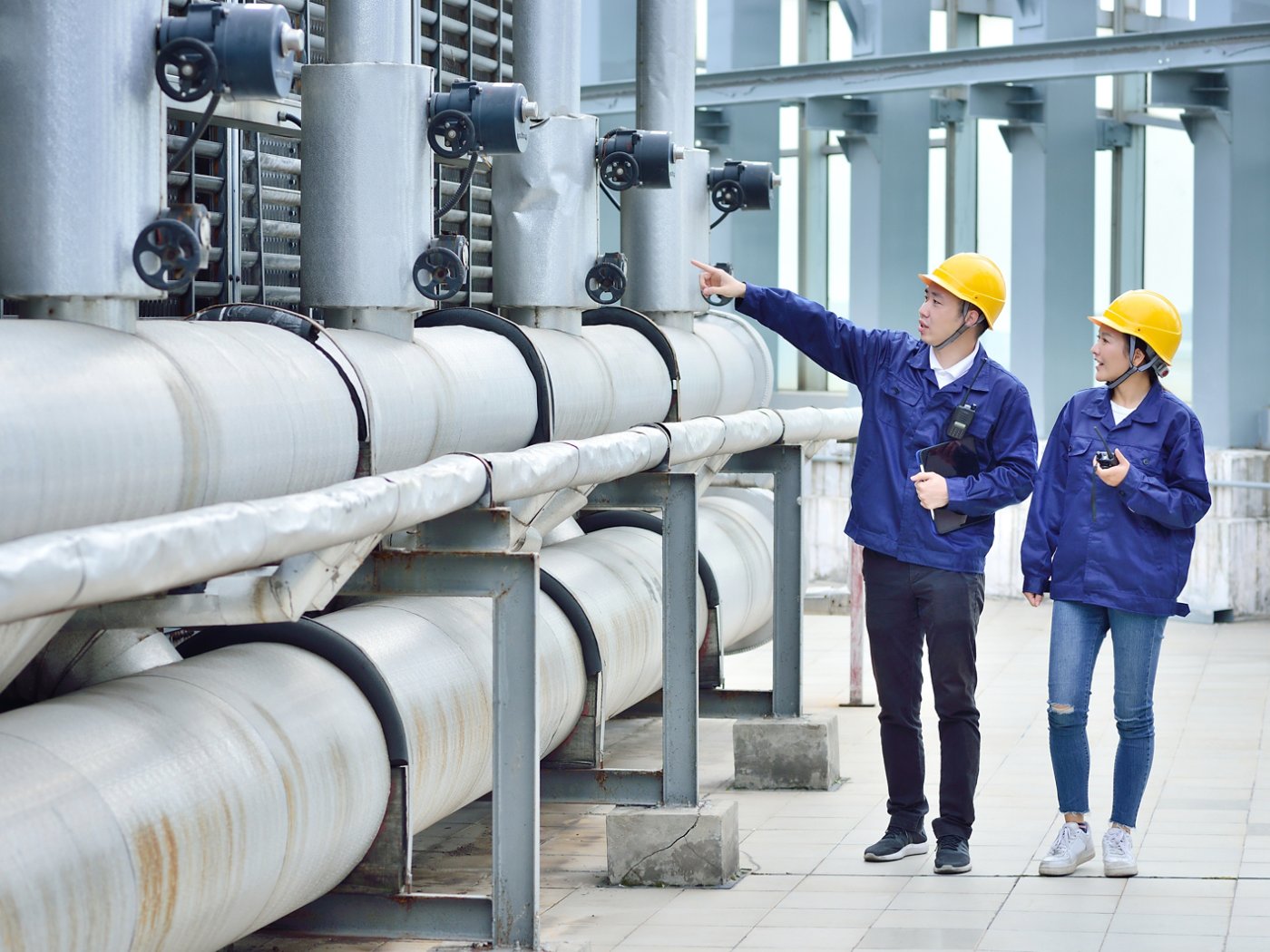 Two engineer colleagues examining to cooling tower equipment.