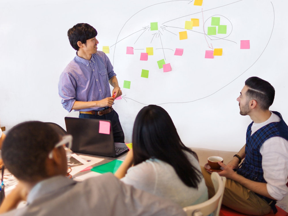 A businessman is giving a presentation in a modern co-working space.