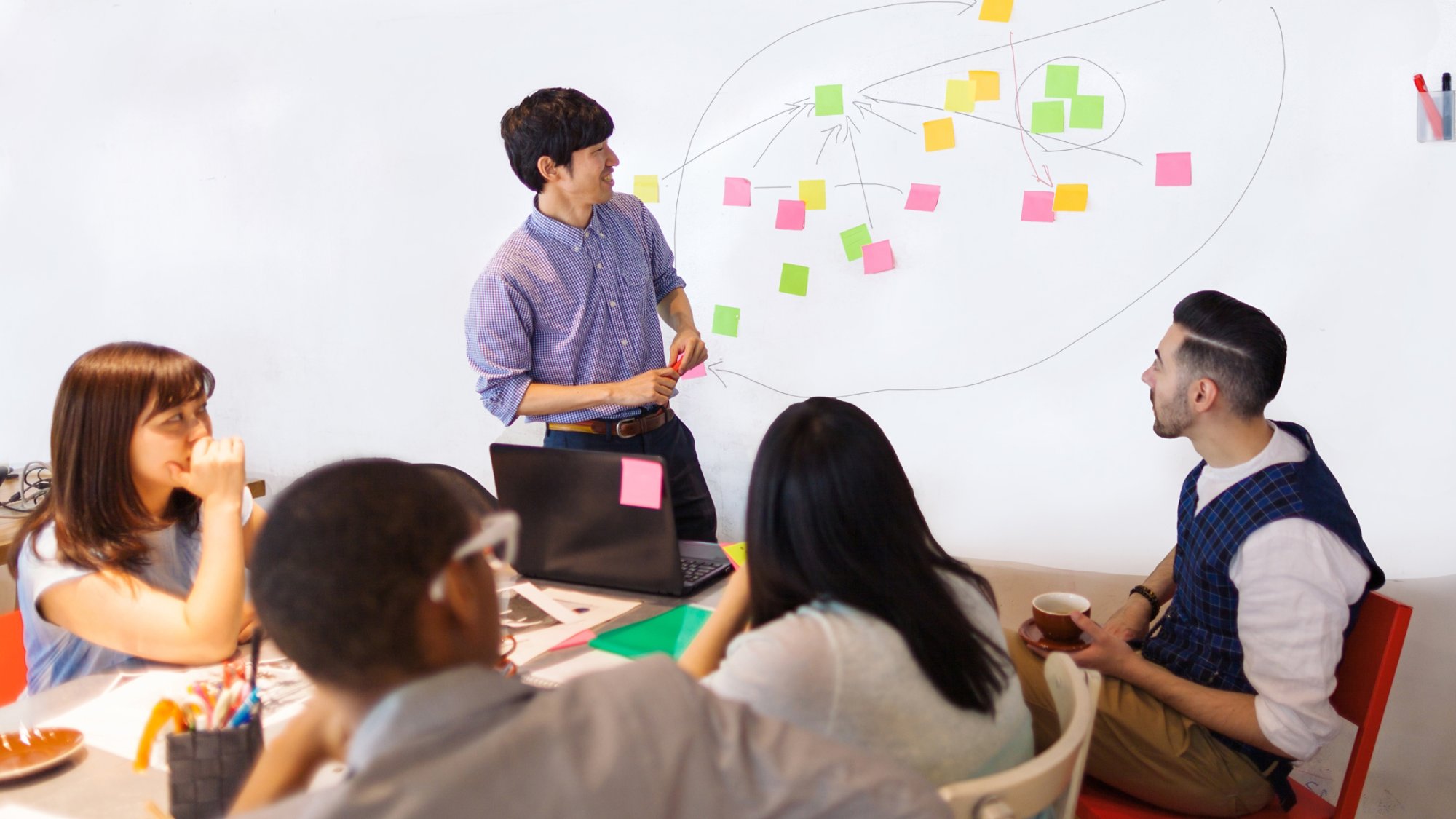 A businessman is giving a presentation in a modern co-working space.