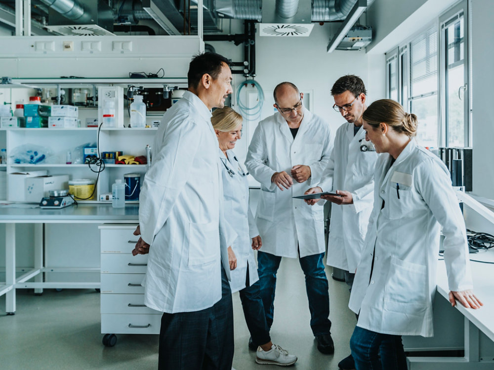 Scientists and doctors with digital tablet, standing in laboratory, NRW, Germany