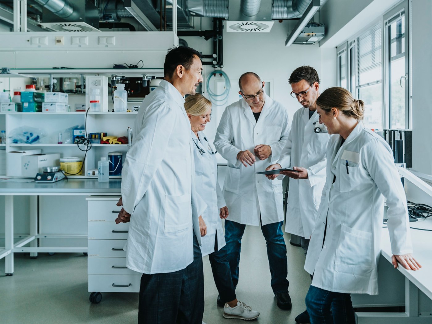 Scientists and doctors with digital tablet, standing in laboratory, NRW, Germany