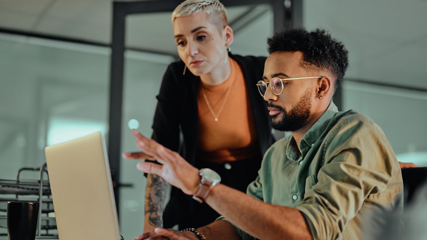 Shot of two young designers working together on a laptop in an office at night