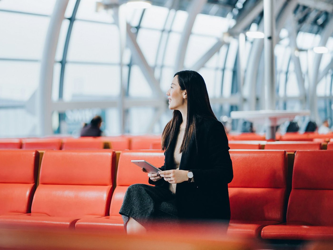 independent businesswoman sitting at the airport waiting for her flight
