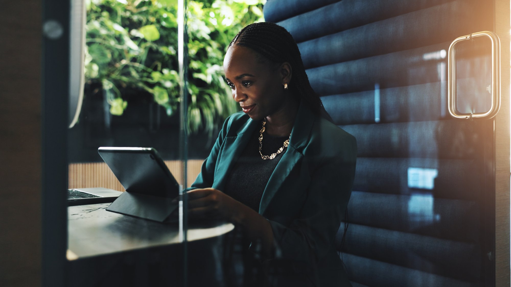 Tablet, office and businesswoman in cubicle for company budget review and accounting news. Technology, hybrid work booth and African financial manager with online investment report or reading update.