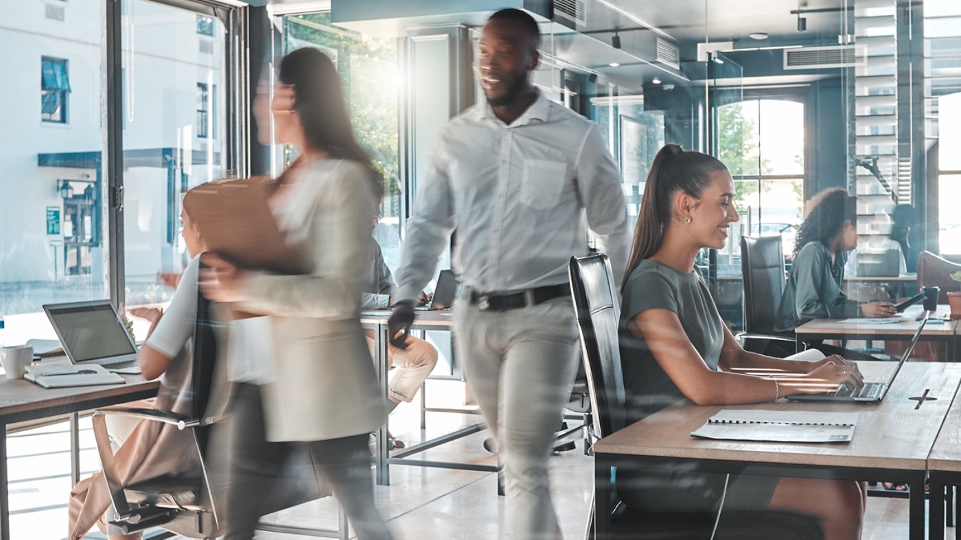 A group of four colleagues standing in an elegant modern office discussing a green energy project