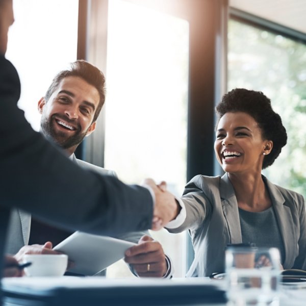 Happy business people, handshake and meeting in teamwork for partnership or collaboration in boardroom. Woman person shaking hands in team recruiting, introduction or b2b agreement at the workplace.