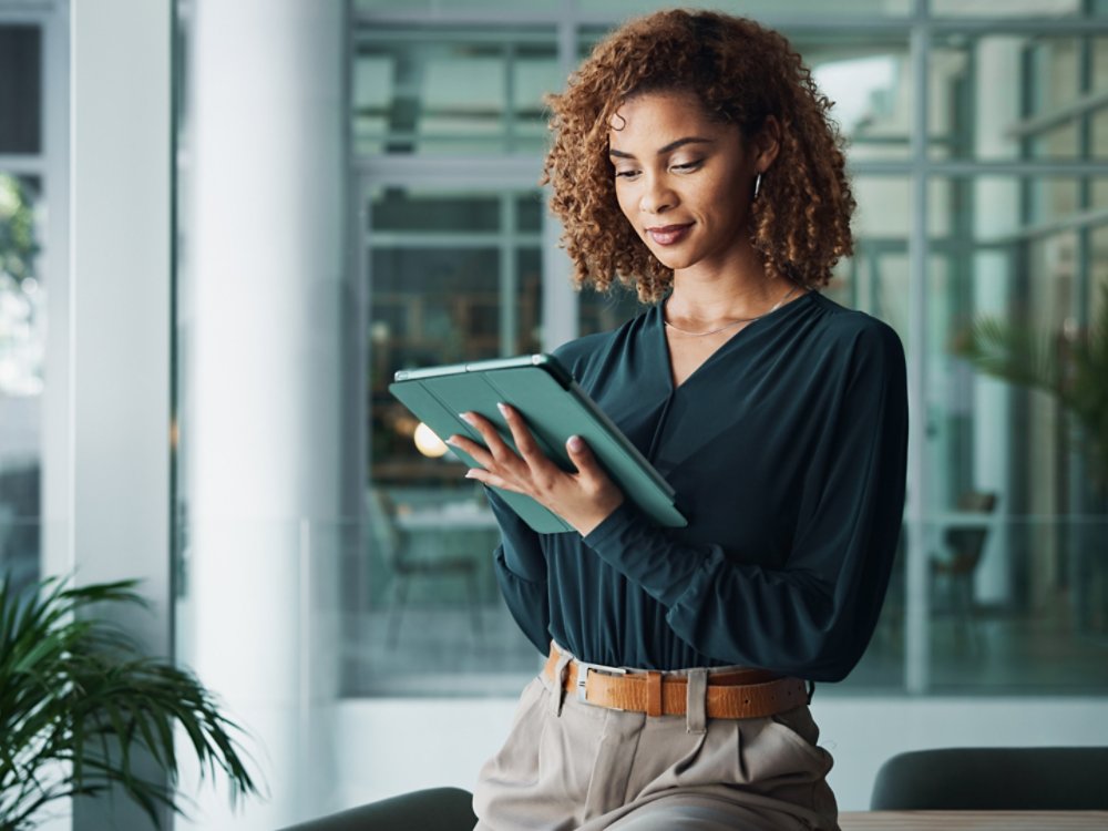 A woman IT professional reviewing AI cloud operations holding a tablet