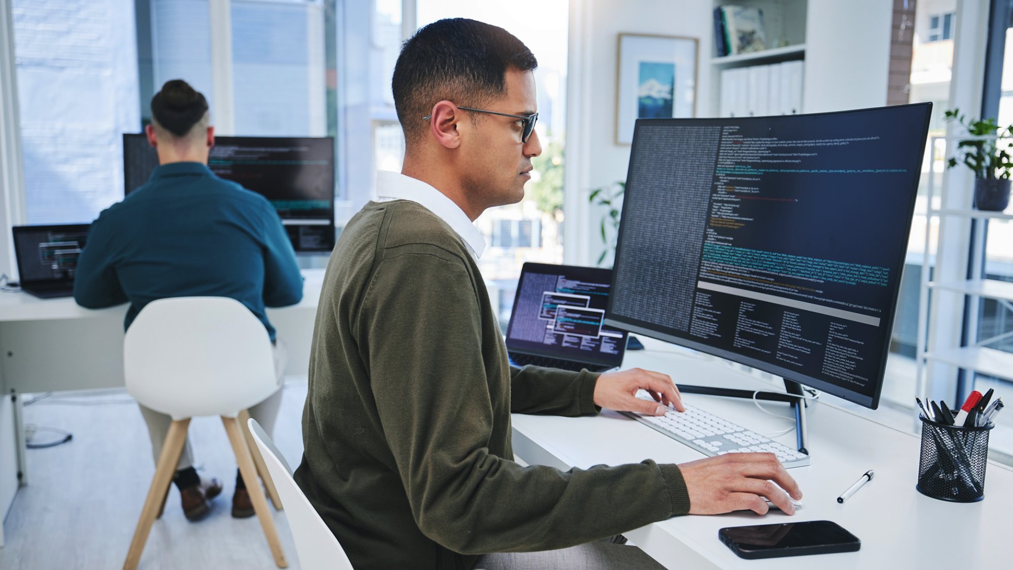 Programming, software developer and a man at computer for coding, script or cyber security in office. IT technician person or programmer with technology for development, future or data analytics.