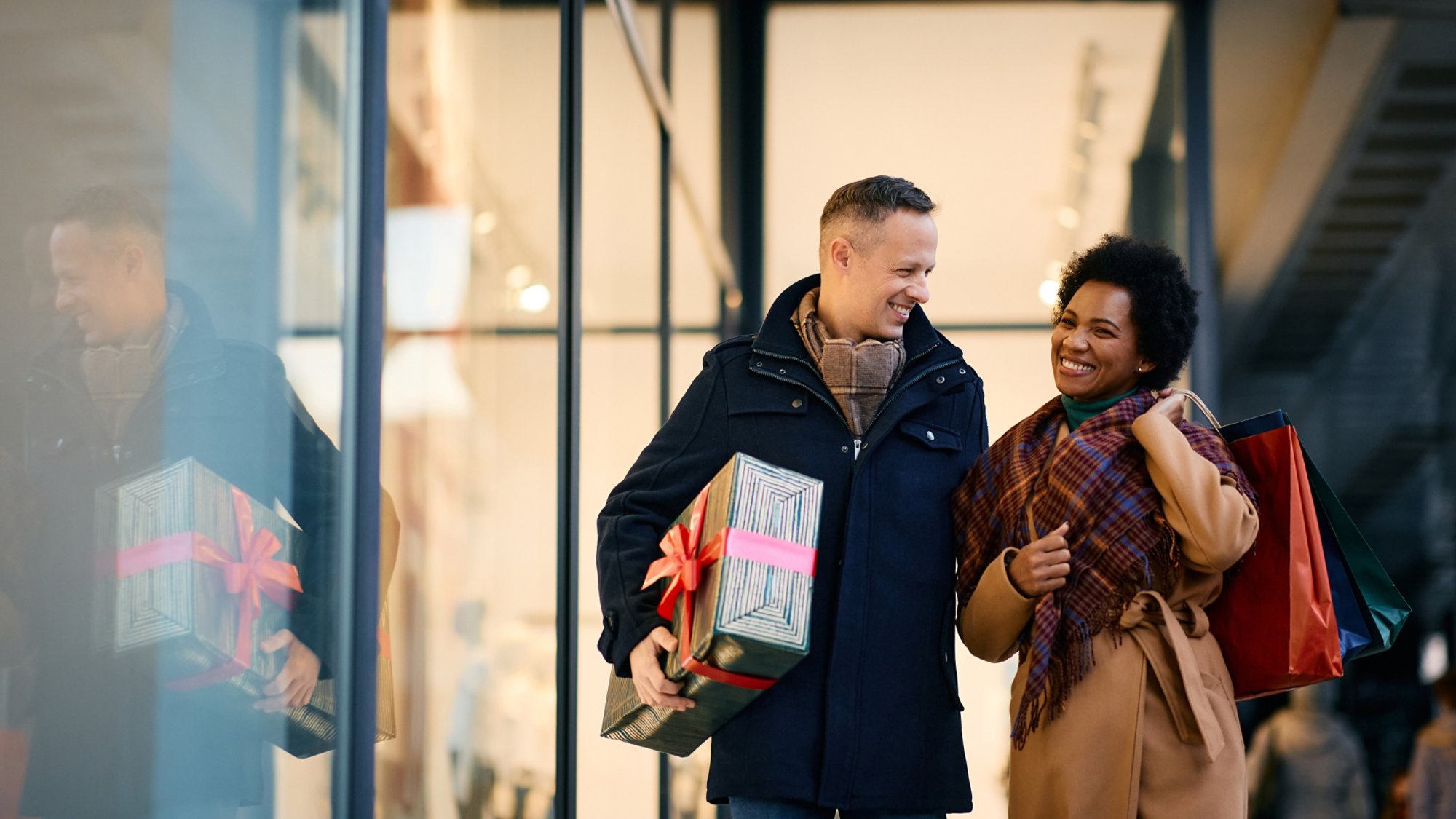 Happy couple enjoying in shopping for Christmas in city.