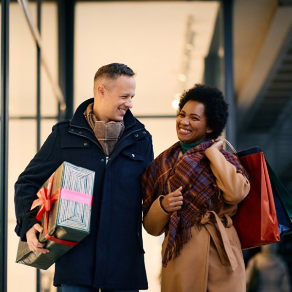 Happy couple enjoying in shopping for Christmas in city.