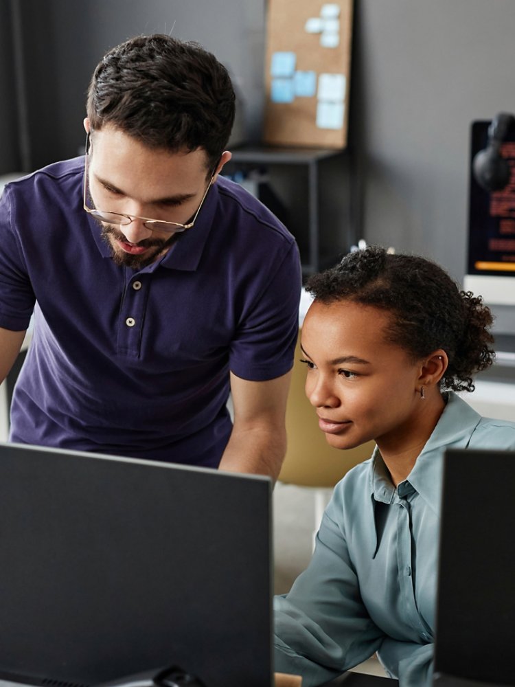 IT professionals discussing over computer in office
