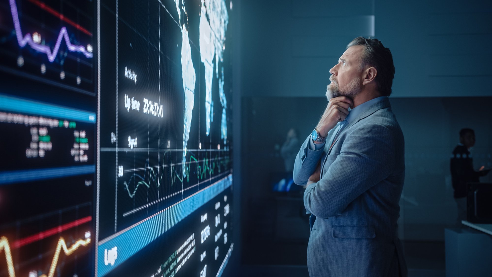 Senior Computer Science Engineer Looking at Big Screen Display Showing Global Map with Data Points. Telecommunications Technology Company System Control and Monitoring Room with Servers.