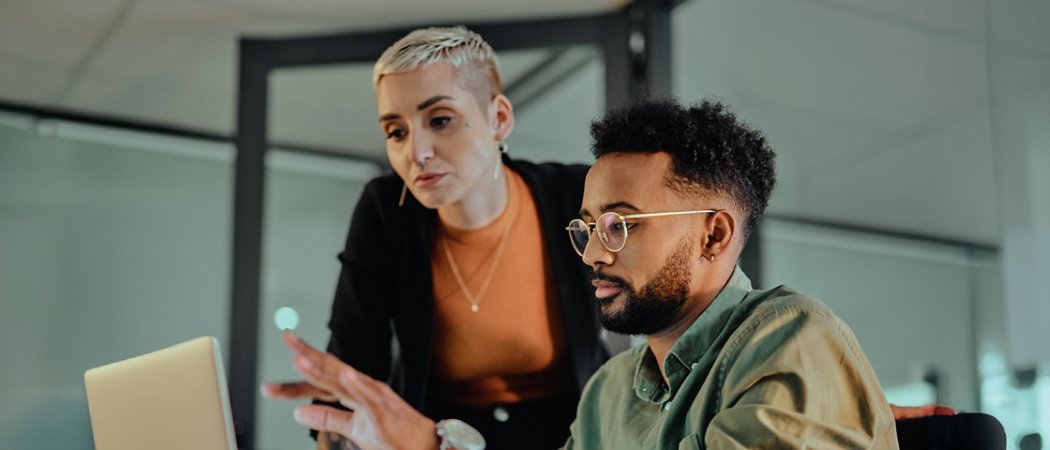 Two people looking at a computer screen discussing work