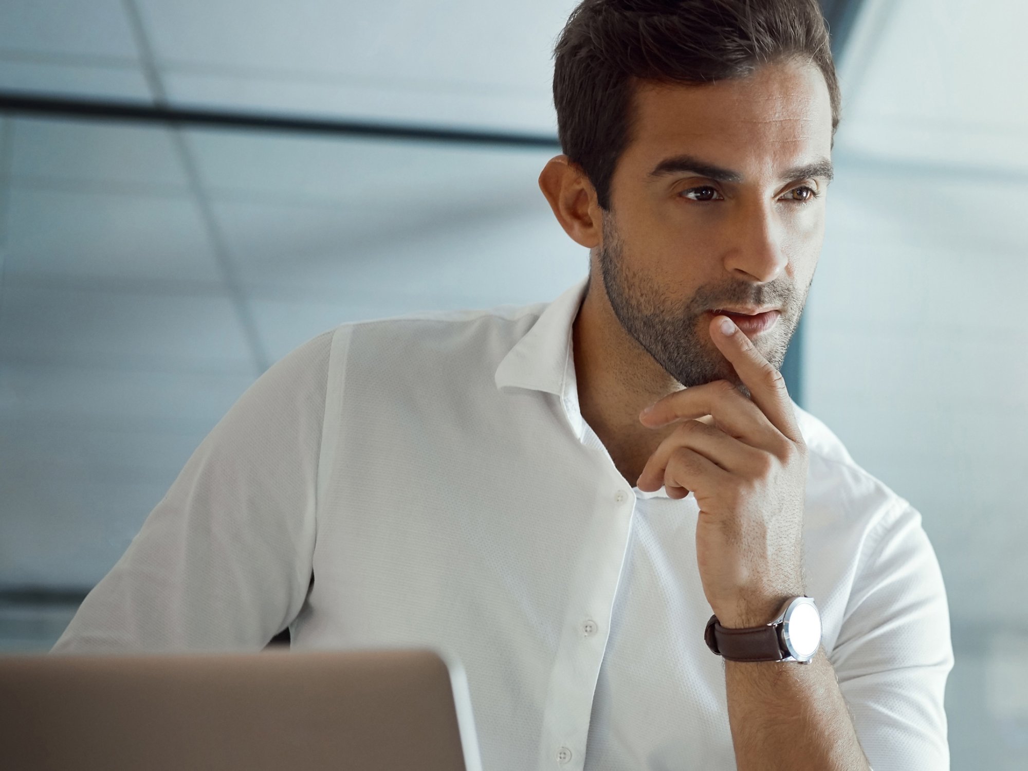 Man looking at mainframe computer using a laptop