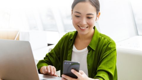 Woman working on laptop and smartphone