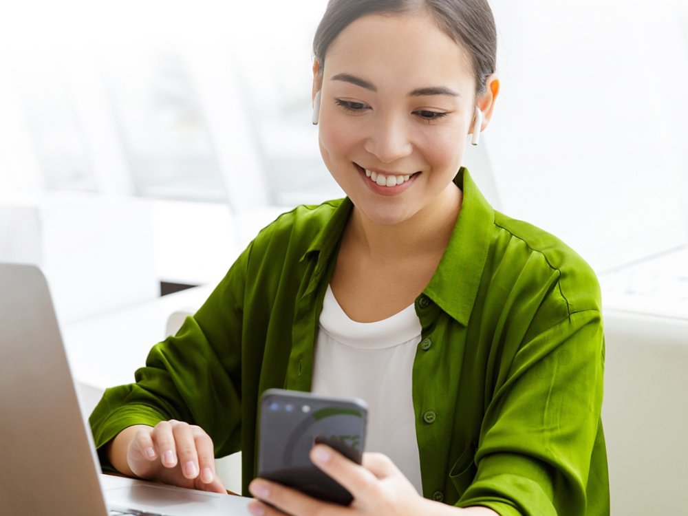 Woman working on laptop and smartphone