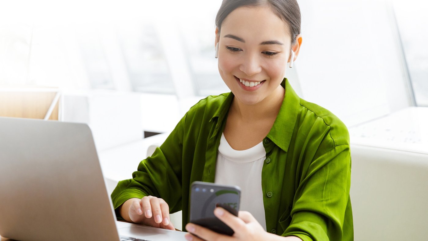 Woman working on laptop and smartphone